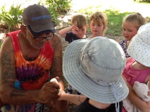 Child holding aboriginal mans hand