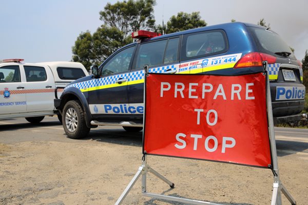 Bicheno, Australia - January 6, 2013: Police and State Emergency Service at the Road to Coles Bay. Because of the massive bushfires the road is closed. Firefighters try to control the fires. Tasmania. Australia