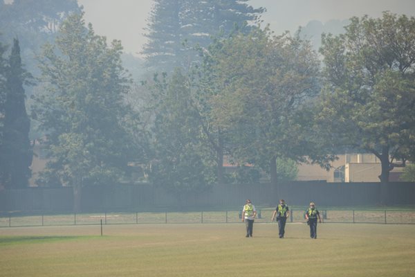 Melbourne, Australia - December 27, 2017: Police officers leave a residential district in Cheltenham after clearing it of people. The area was filled with smoke after a bushfire broke out.